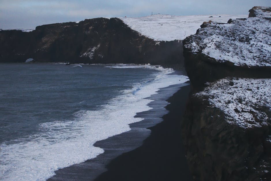 Image of Reynisfjara Black Sand Beach, showing the contrast between black sand and the ocean waves.